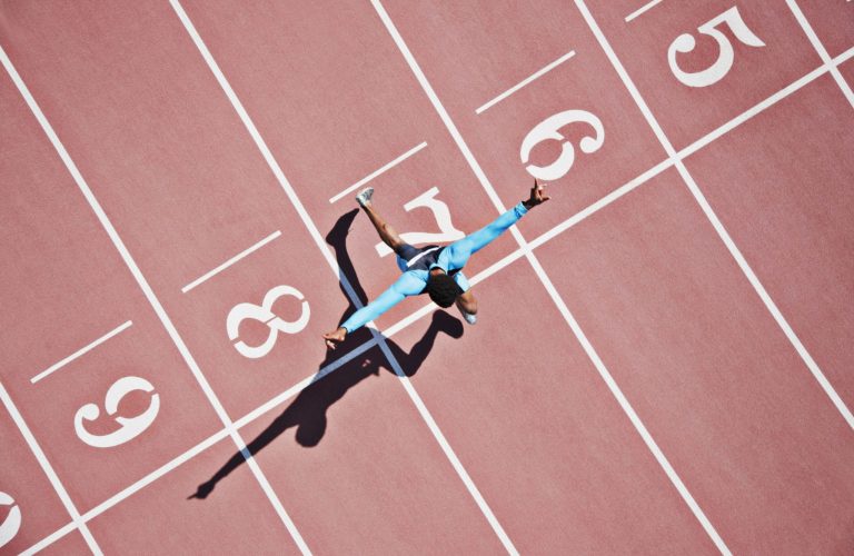 Runner crossing finishing line on track Runner crossing finishing line on track